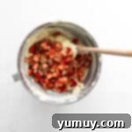 folding chopped strawberries and rhubarb into cake batter with a rubber spatula.