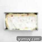 cake batter topped with sugar in a loaf pan.