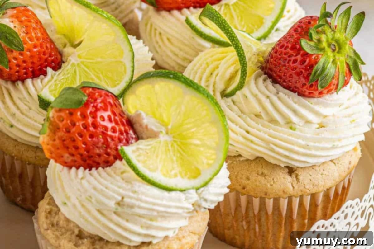 Last Hurrah of Summer Desserts 6 Festive Strawberry Margarita Cupcakes arranged beautifully on a multi-tiered cake stand, garnished with fresh sliced strawberries and bright lime wheels.