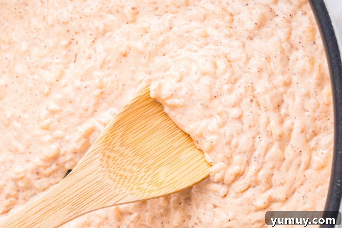 closeup of cooked rice pudding with a wooden spoon.