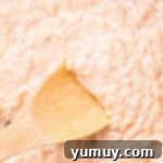 closeup of cooked rice pudding with a wooden spoon.