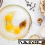 German Chocolate Coconut Pecan Delight Pie 10 Eggs, sugar, and vanilla in a glass bowl.