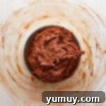 Sticky chocolate cookie dough in a glass bowl after combining wet and dry ingredients.