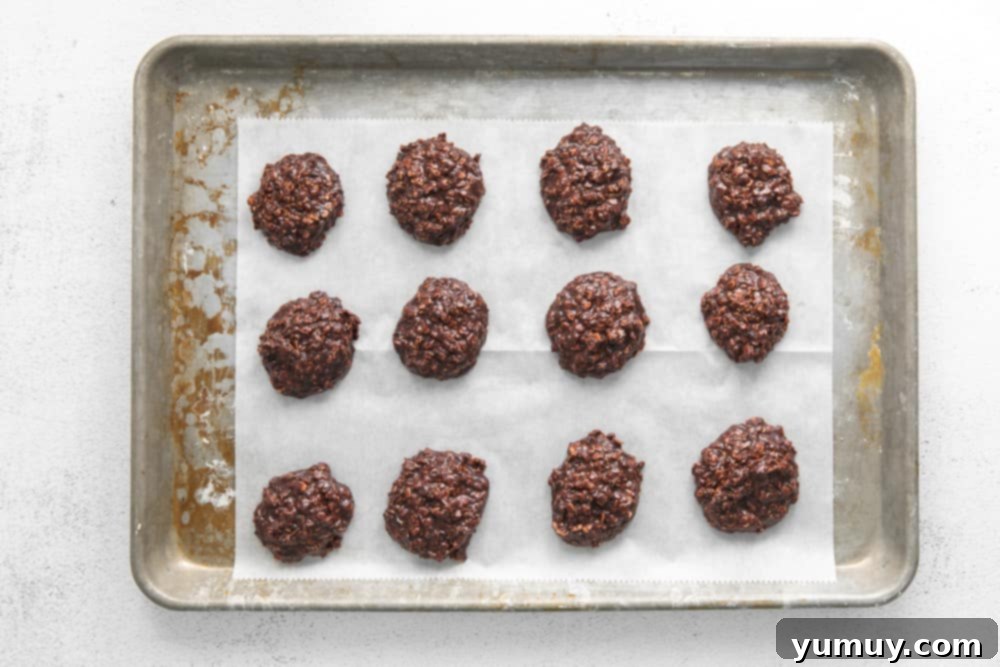 no bake cookies lined up on a baking tray covered with parchment paper