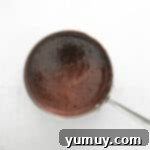 chocolate sauce in a spoon on a white background.