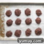 no bake cookies lined up on a baking tray covered with parchment paper