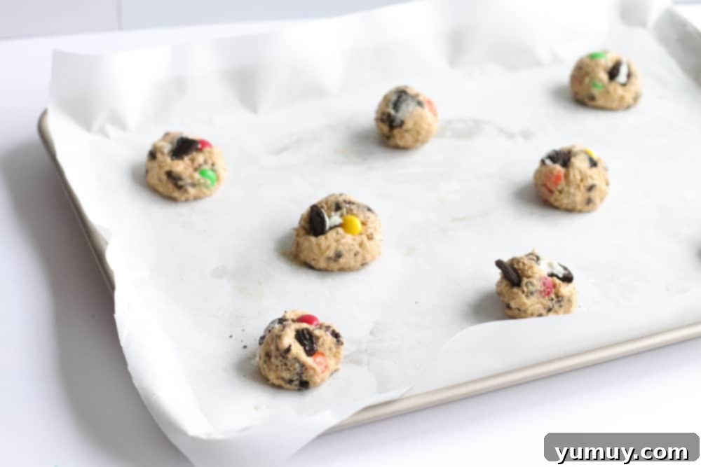 Neatly arranged cookie dough balls on a parchment-lined baking tray, perfectly spaced.