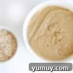 Overhead view of a large bowl of cookie batter, with a smaller bowl of oats next to it, ready to be added.