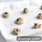 Perfectly portioned cookie dough balls arranged on a parchment-lined baking tray.