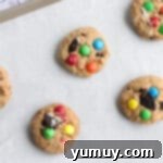 Delicious Oreo monster cookies cooling on a parchment-lined baking tray after coming out of the oven.
