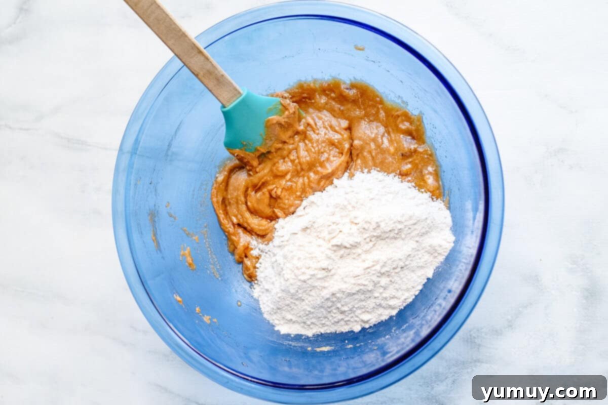 A close-up of the blondie batter in a bowl, with dry ingredients just mixed in, ready for toppings