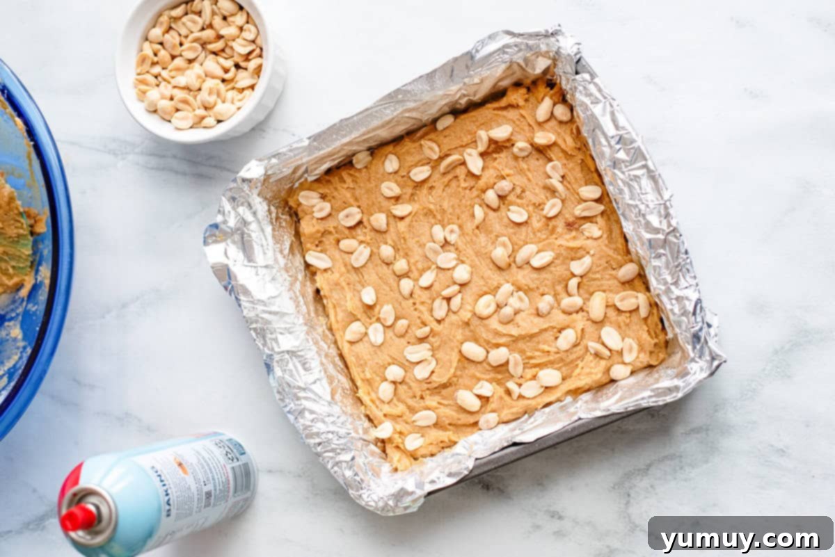 A baking pan filled with golden-brown peanut butter blondies cooling on a wire rack