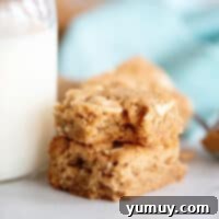 Two golden peanut butter blondies stacked, a visual promise of deliciousness