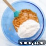 A bowl containing mixed wet and dry ingredients for blondies, showing the batter consistency