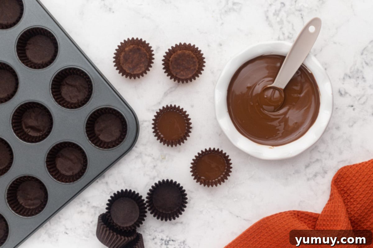 Step 3: Spooning melted chocolate into the base of each mini cupcake liner.
