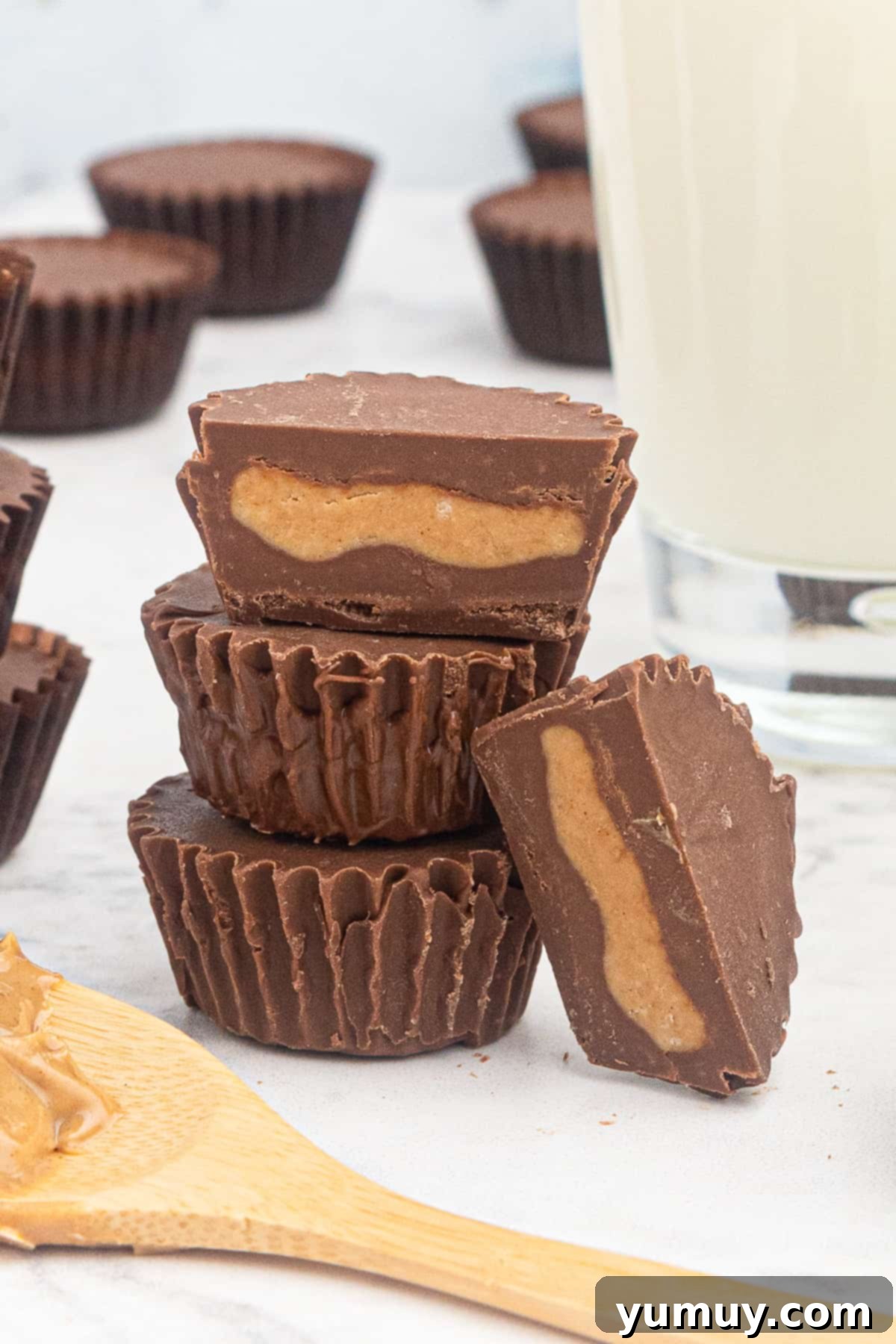 A close-up of four perfectly formed homemade peanut butter cups, showcasing their smooth chocolate exterior.