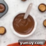 Melted chocolate in a bowl, ready for homemade peanut butter cups.