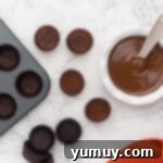 Placing the first layer of chocolate into mini cupcake liners.