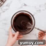 melted chocolate and butter in a glass bowl with a whisk.