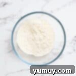 All-purpose flour in a clear glass mixing bowl, positioned for microwave heat treatment.