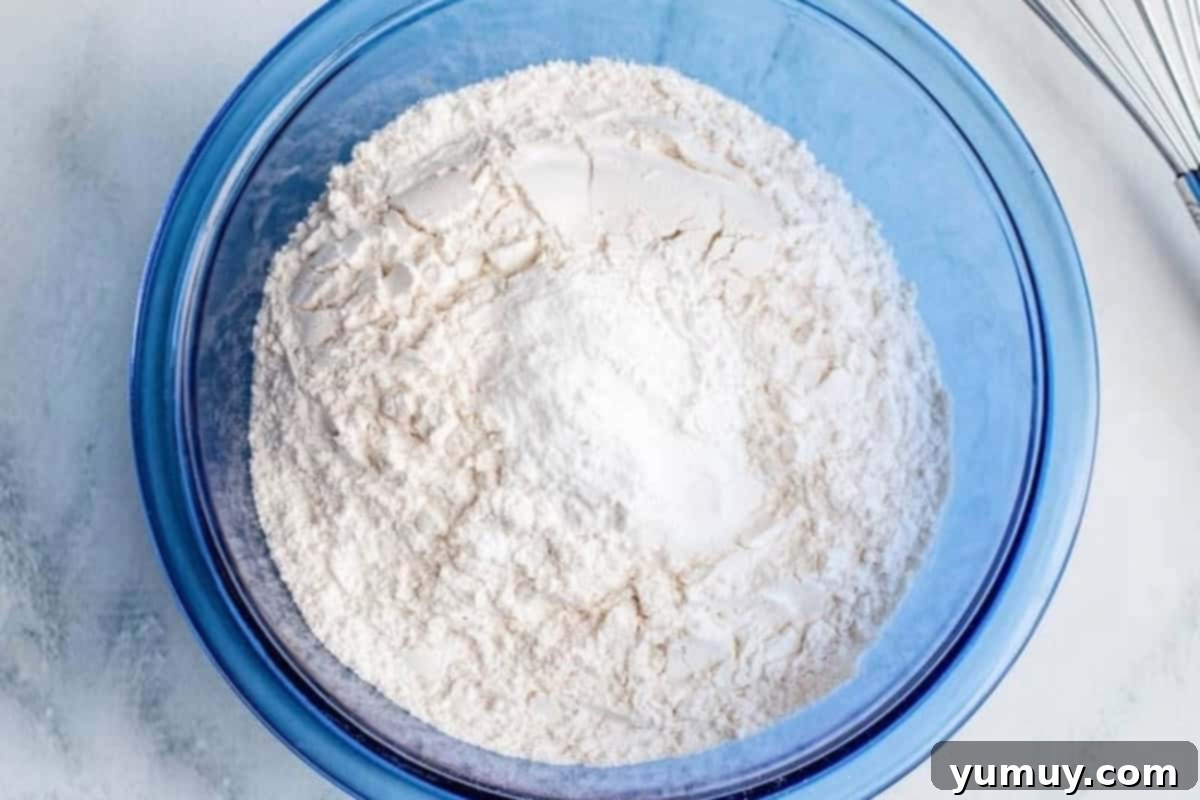 A glass mixing bowl filled with all-purpose flour, ready for microwave heat treatment.