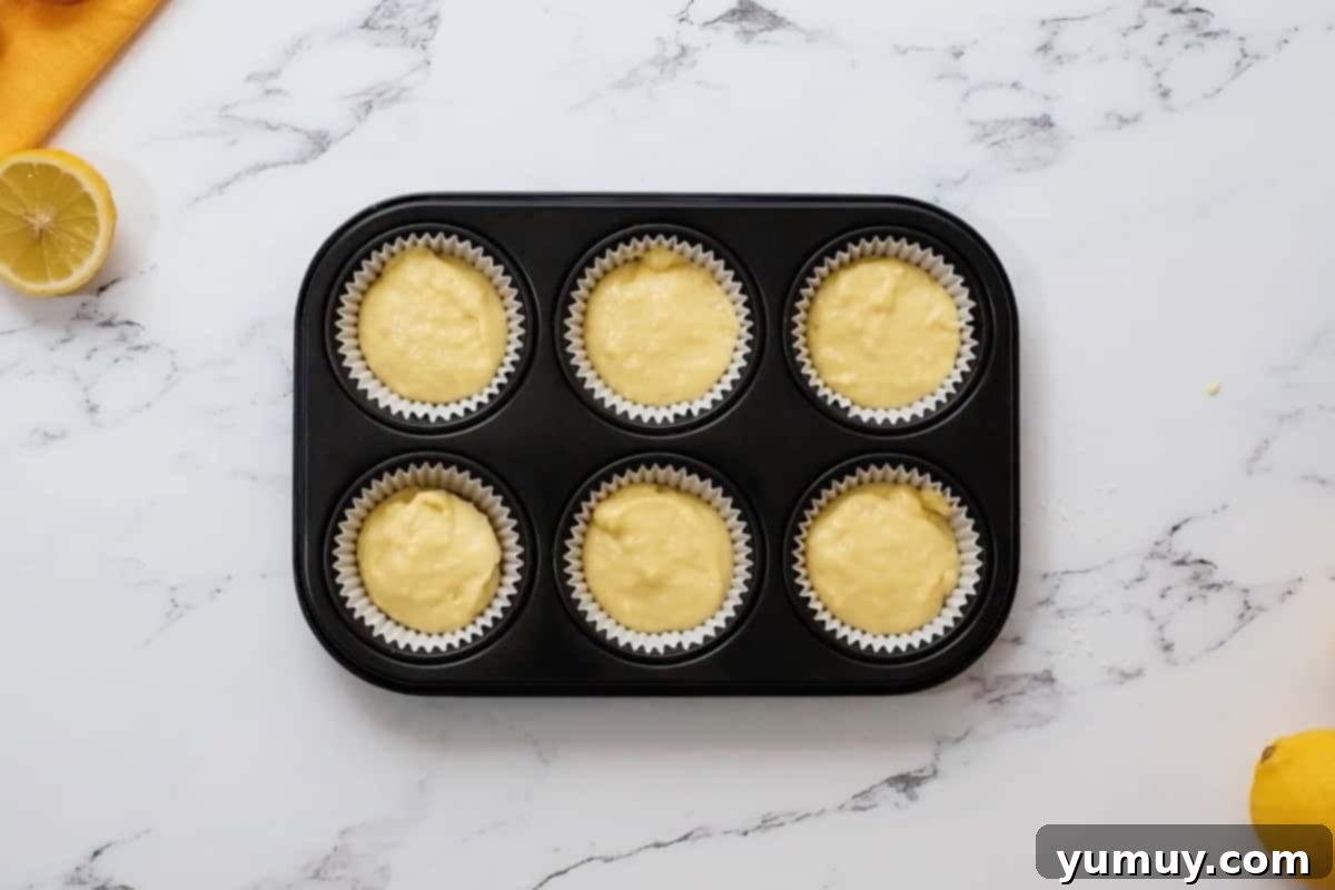 lemon cupcake batter portioned in a cupcake tin.
