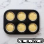 lemon cupcake batter portioned in a cupcake tin.
