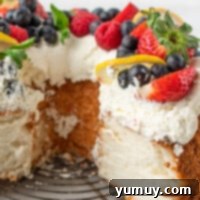 Sliced lemon angel food cake garnished with whipped cream and fruit