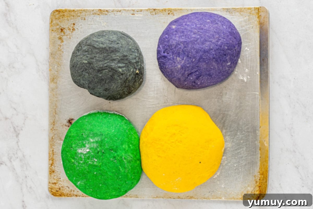 Enchanted Halloween Loaves 18 Four different colored dough balls on a baking sheet.