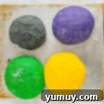 Enchanted Halloween Loaves 8 four different colored dough balls on a baking sheet.