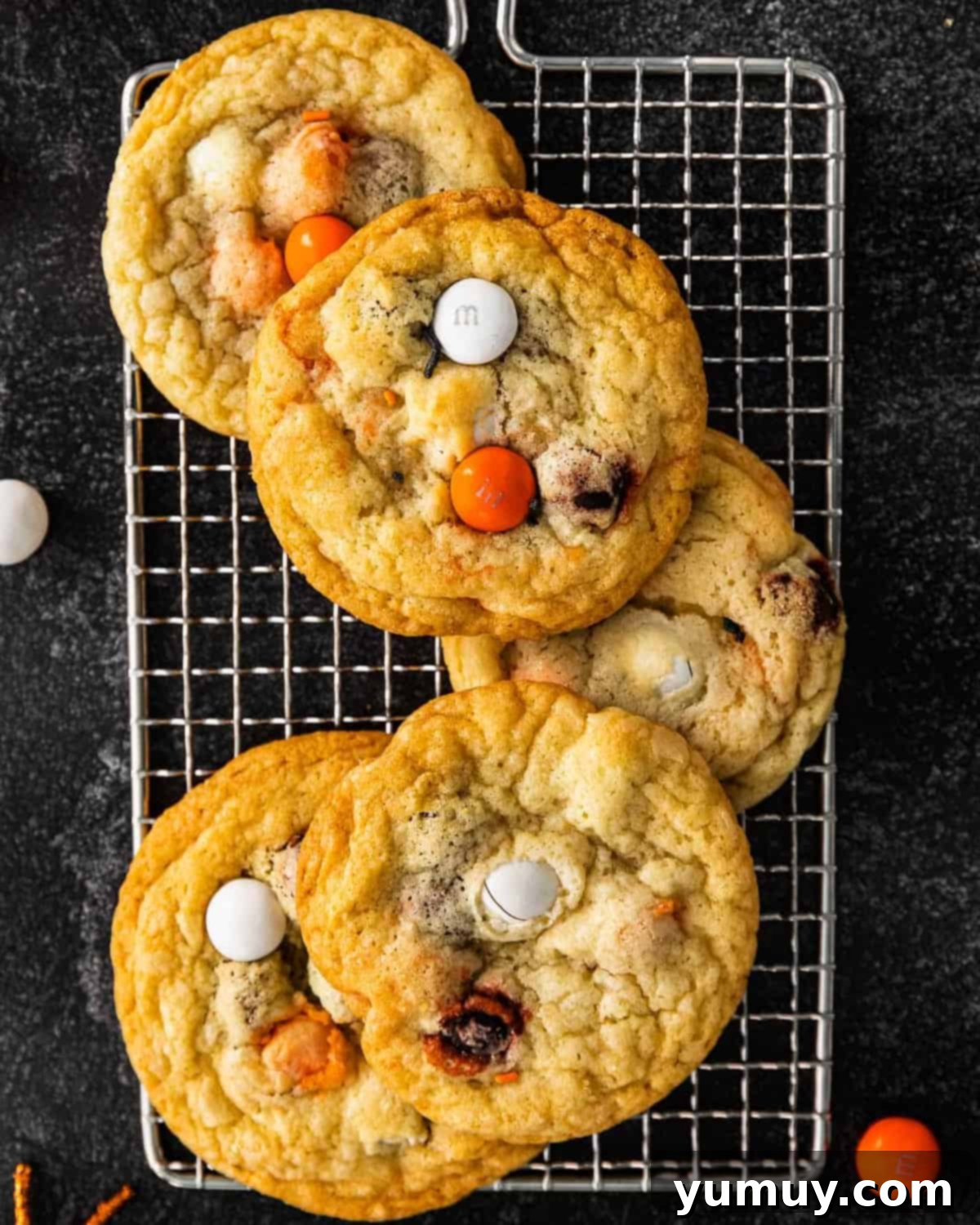 overhead view of five halloween m&m cookies on a cooling rack.