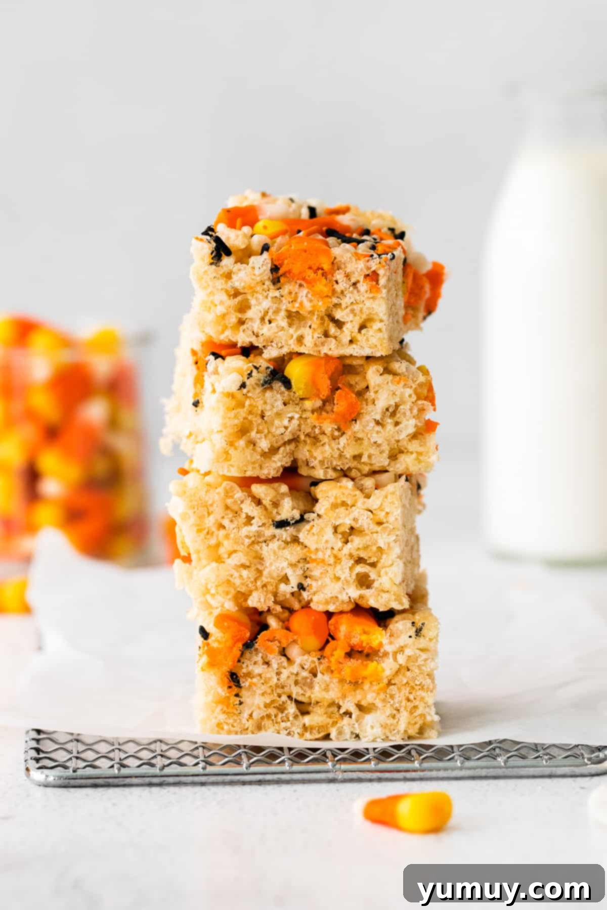 Spooky Crispy Halloween Squares 2 A stack of Halloween Rice Krispie treats filled with candy corn and sprinkles.