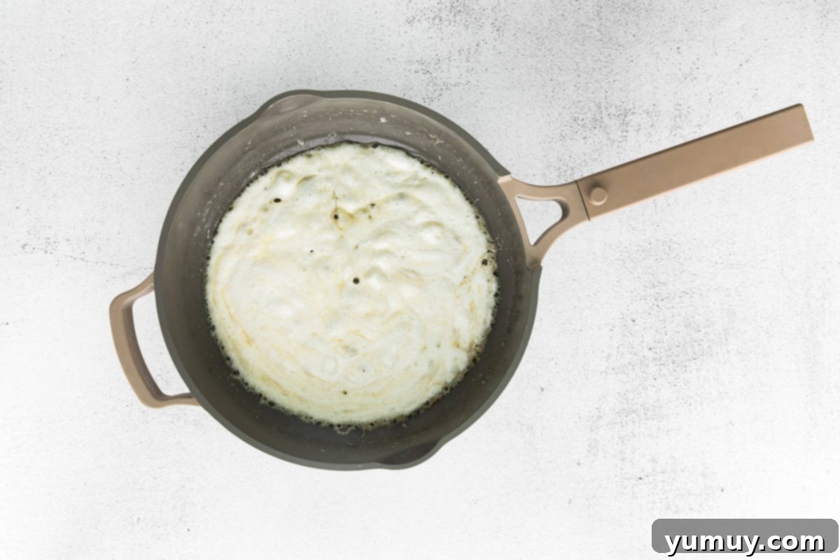 Spooky Crispy Halloween Squares 11 Marshmallow melting in a pot.