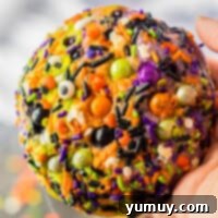 holding up halloween sprinkle cookie