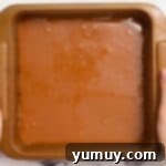 A perfectly set layer of caramel atop the shortbread, chilling in a baking pan.