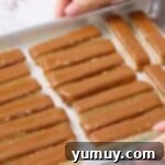 Uniformly sliced cookie and caramel bars neatly arranged on a baking tray, ready for a quick freeze.