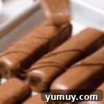 The finishing touch: drizzling melted chocolate over homemade candy bars for an appealing aesthetic.