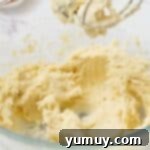 Shortbread cookie dough forming into a soft, cohesive ball in a mixing bowl.