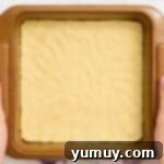 A freshly baked layer of cookie dough, perfectly golden, resting in a baking pan.