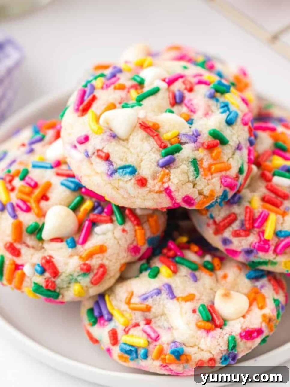 stacked funfetti cookies on white plate
