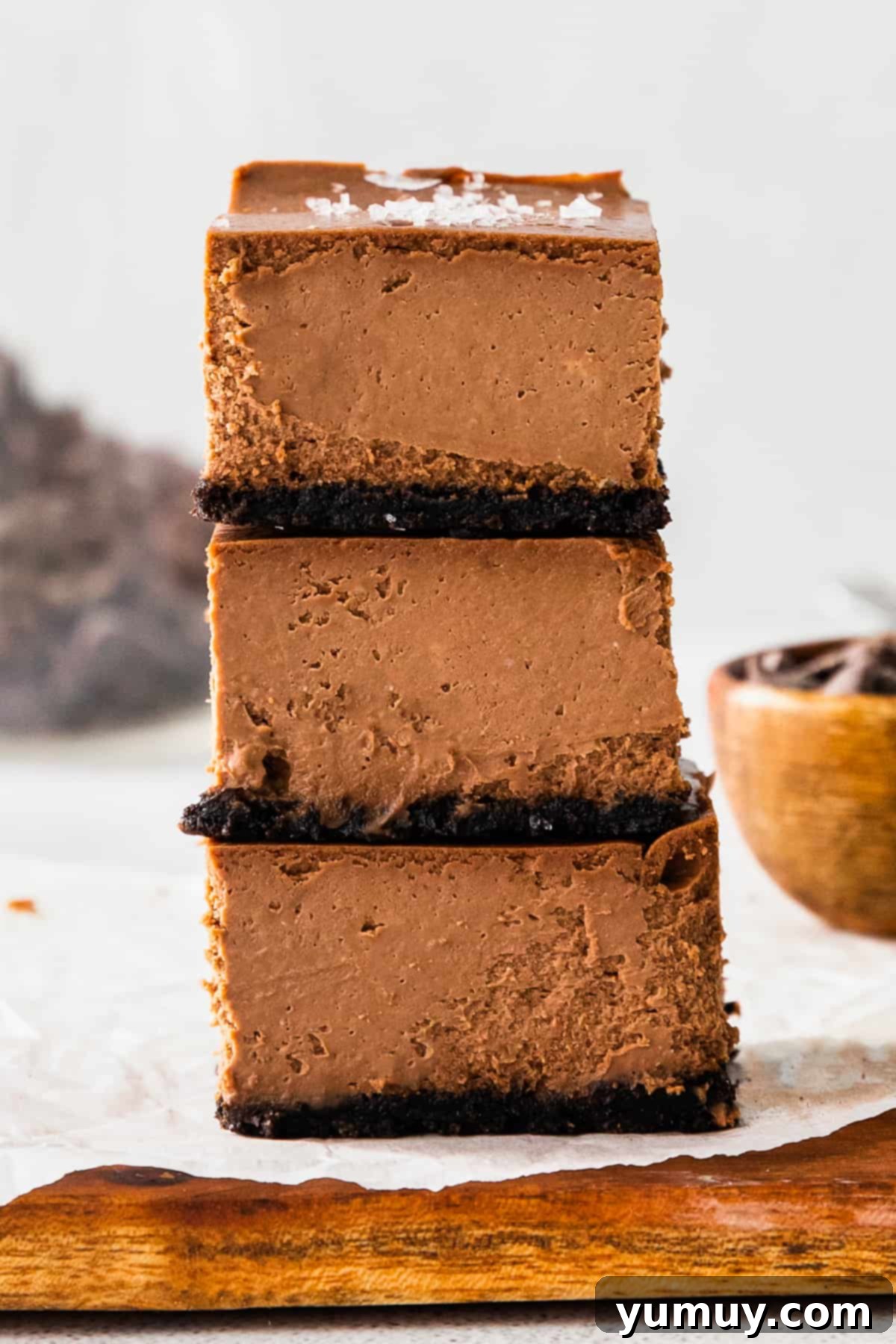 Up close stacked chocolate cheesecake bars with a sprinkle of sea salt