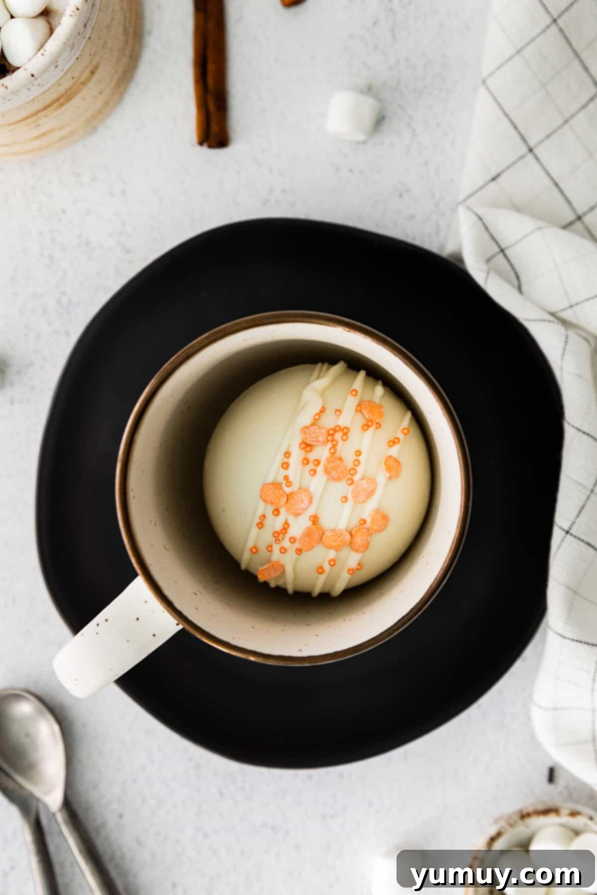 Pumpkin spice hot cocoa bomb melting in a mug, surrounded by fall leaves and a cozy ambiance.