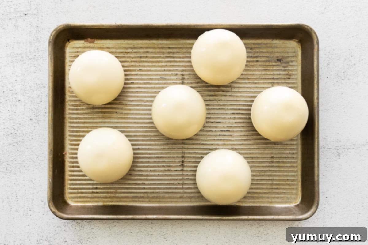 Sealing two chocolate half-spheres to form a complete hot cocoa bomb.