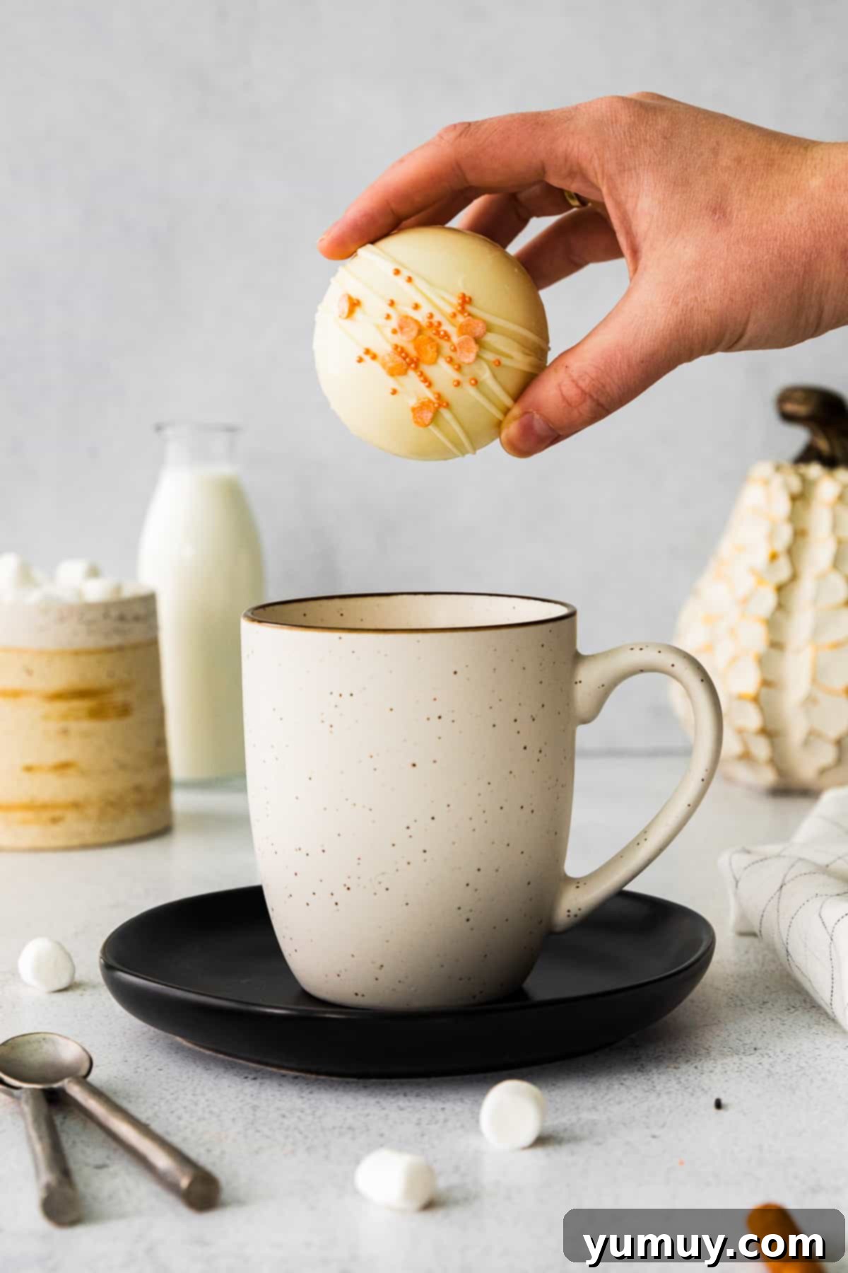 Close-up of a pumpkin hot cocoa bomb in a mug, ready to melt into a creamy drink.