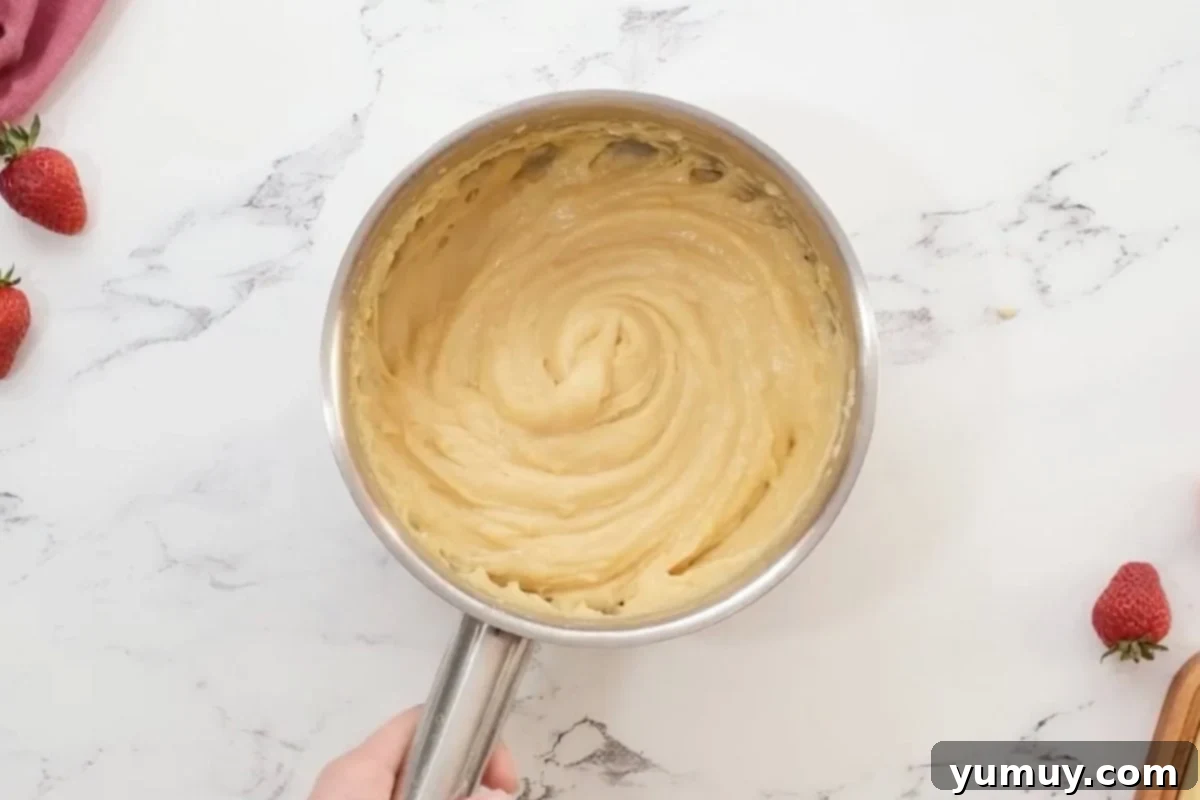Choux pastry dough in a saucepan after stirring and cooking, ready for piping.