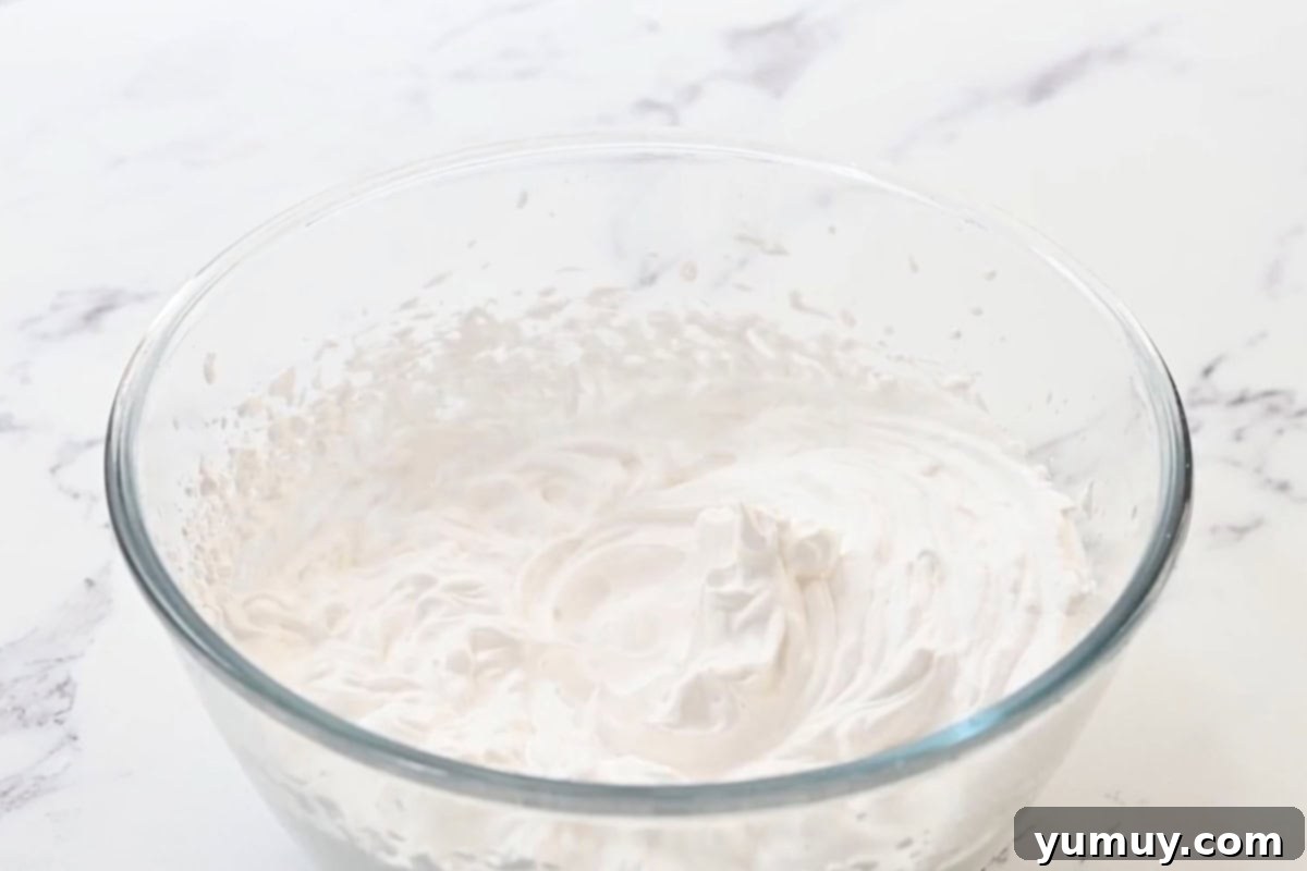 Sweetened whipped cream in a glass bowl, perfectly whipped.