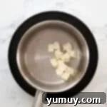 Melting cubes of butter in water in a saucepan.
