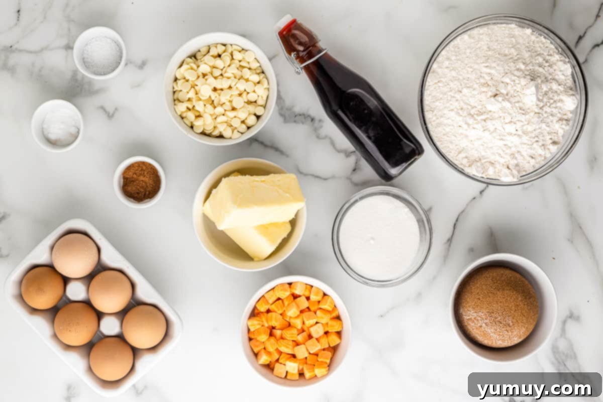 All the necessary ingredients for pumpkin spice cookies laid out: flour, brown sugar, eggs, vanilla, white chocolate chips, pumpkin spice chips, and butter.