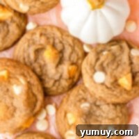 Top-down view of white chocolate pumpkin spice cookies on a pink table, ready to be served.