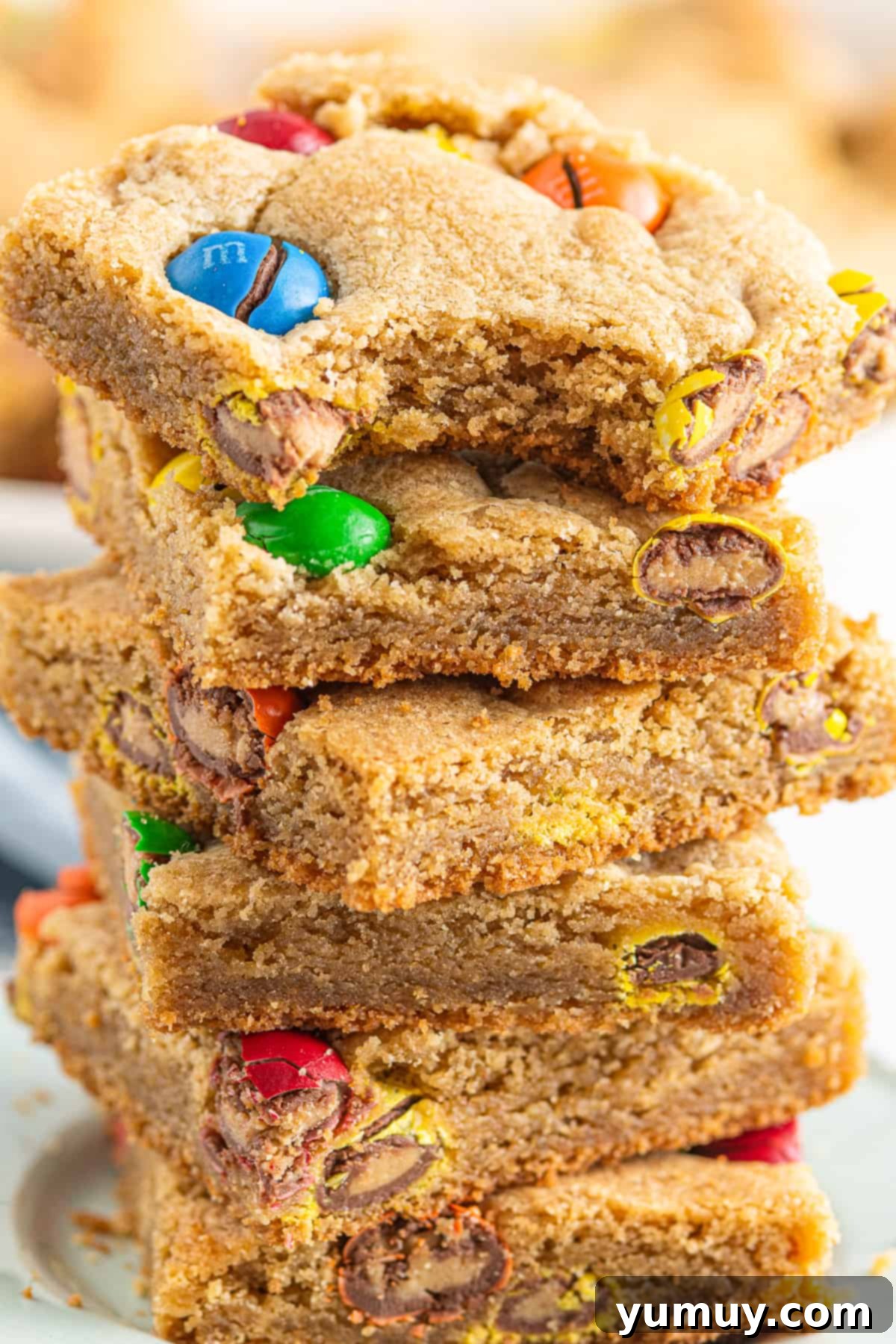 Peanut Butter M&M Blondie Bliss 3 Close-up stack of M&M Peanut Butter Blondies, showing the gooey center and colorful candies.